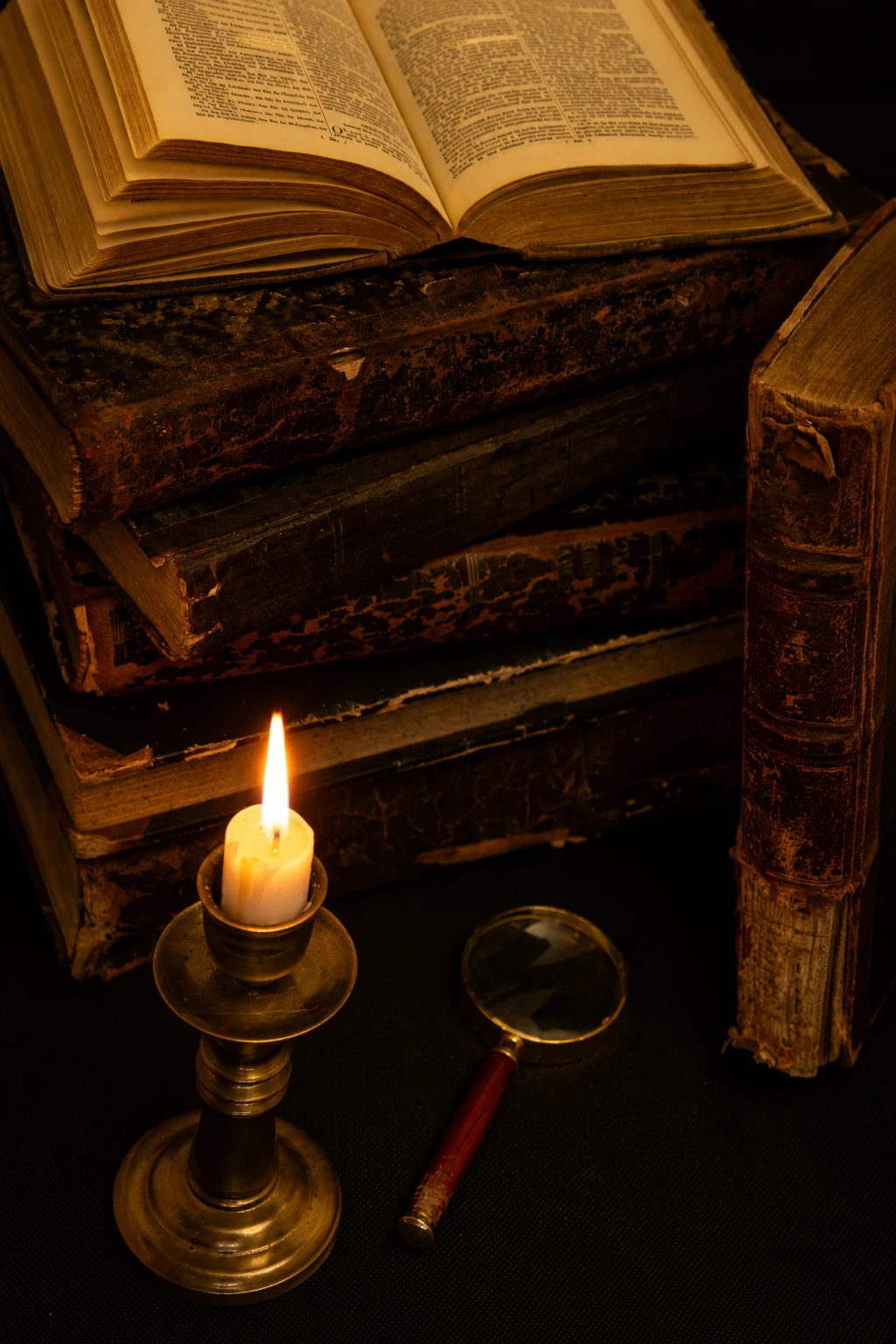 Vieux livres et bougie dans une bibliothèque ancienne
